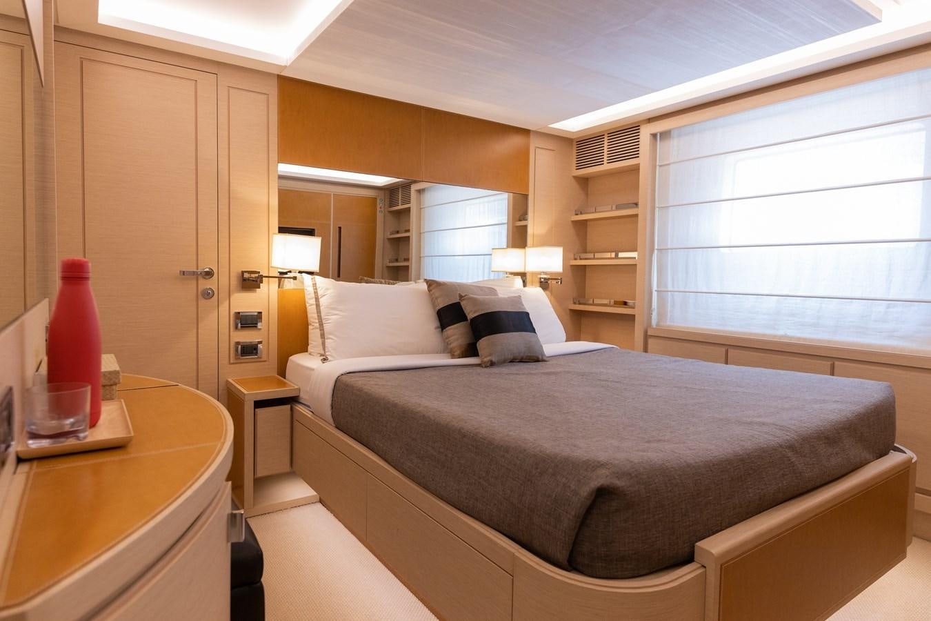 a bedroom with a bed and a desk aboard LIBERTY CALL Yacht for Sale