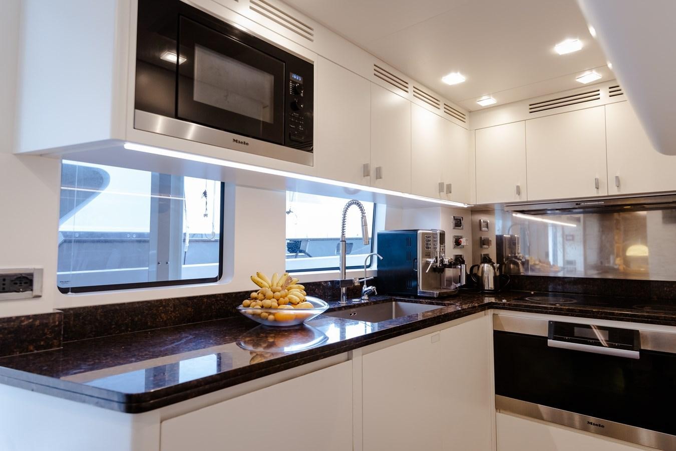 a kitchen with white cabinets aboard LIBERTY CALL Yacht for Sale