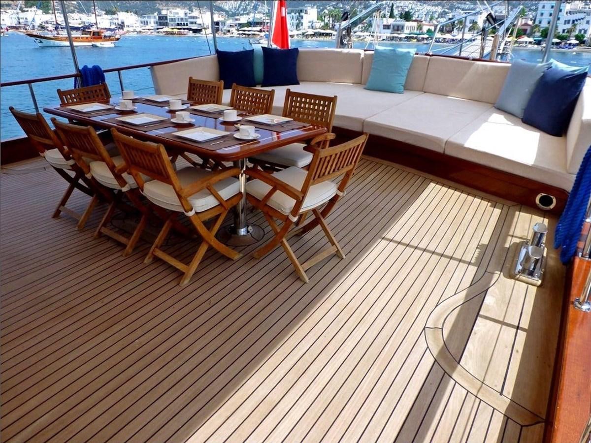 a deck with tables and chairs aboard ELIFIM 11 Yacht for Sale
