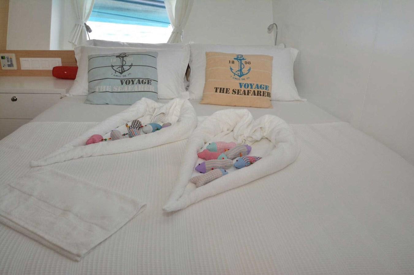 a bed with a white sheet and a pair of shoes on it aboard ELIFIM 11 Yacht for Sale