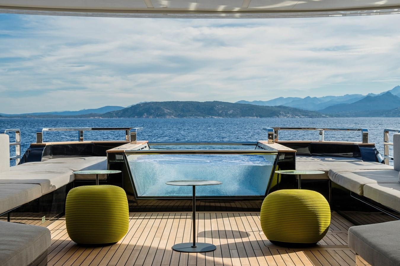 a deck with a view of the ocean and mountains in the background aboard ISA GT 45 Yacht for Sale