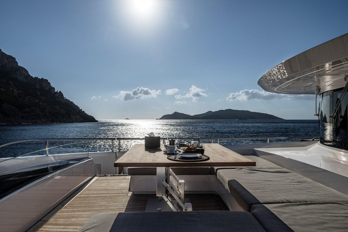 a deck with a view of the ocean and mountains in the background aboard ISA GT 45 Yacht for Sale