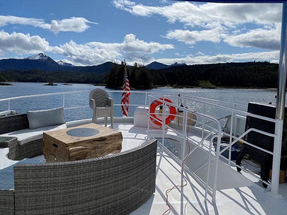 a deck with chairs and a fire pit on it aboard BEAR PAW Yacht for Sale
