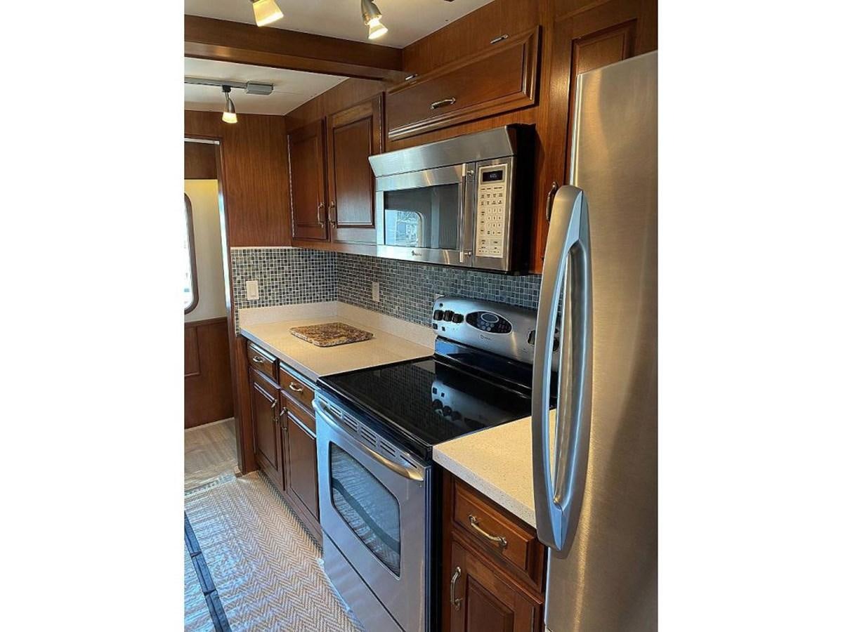 a kitchen with a stainless steel refrigerator aboard BEAR PAW Yacht for Sale