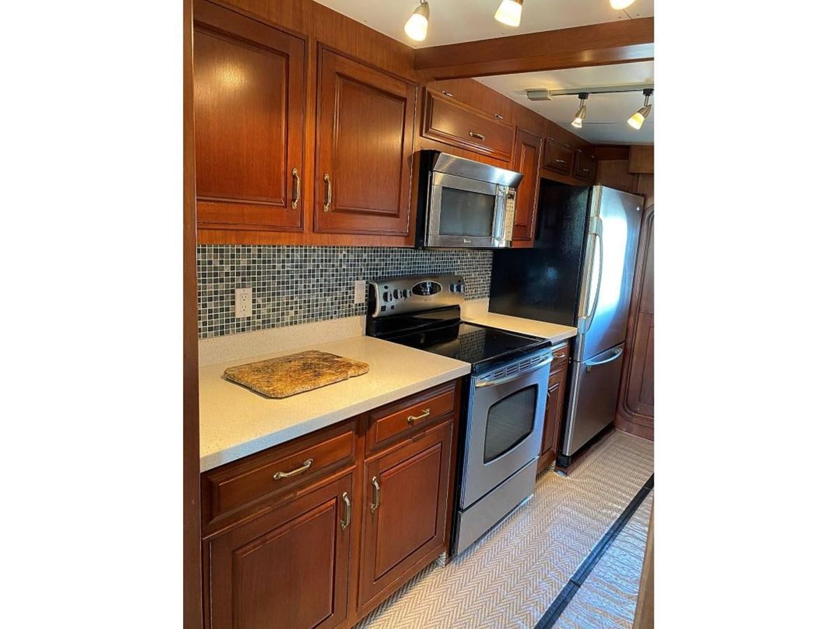 a kitchen with wooden cabinets aboard BEAR PAW Yacht for Sale