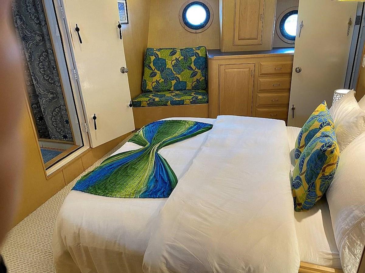 a bed with a blue blanket aboard BEAR PAW Yacht for Sale