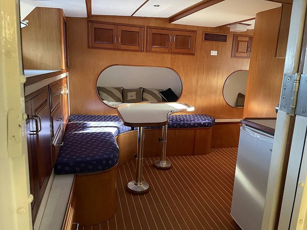 a kitchen with a bar stool and a table aboard BEAR PAW Yacht for Sale