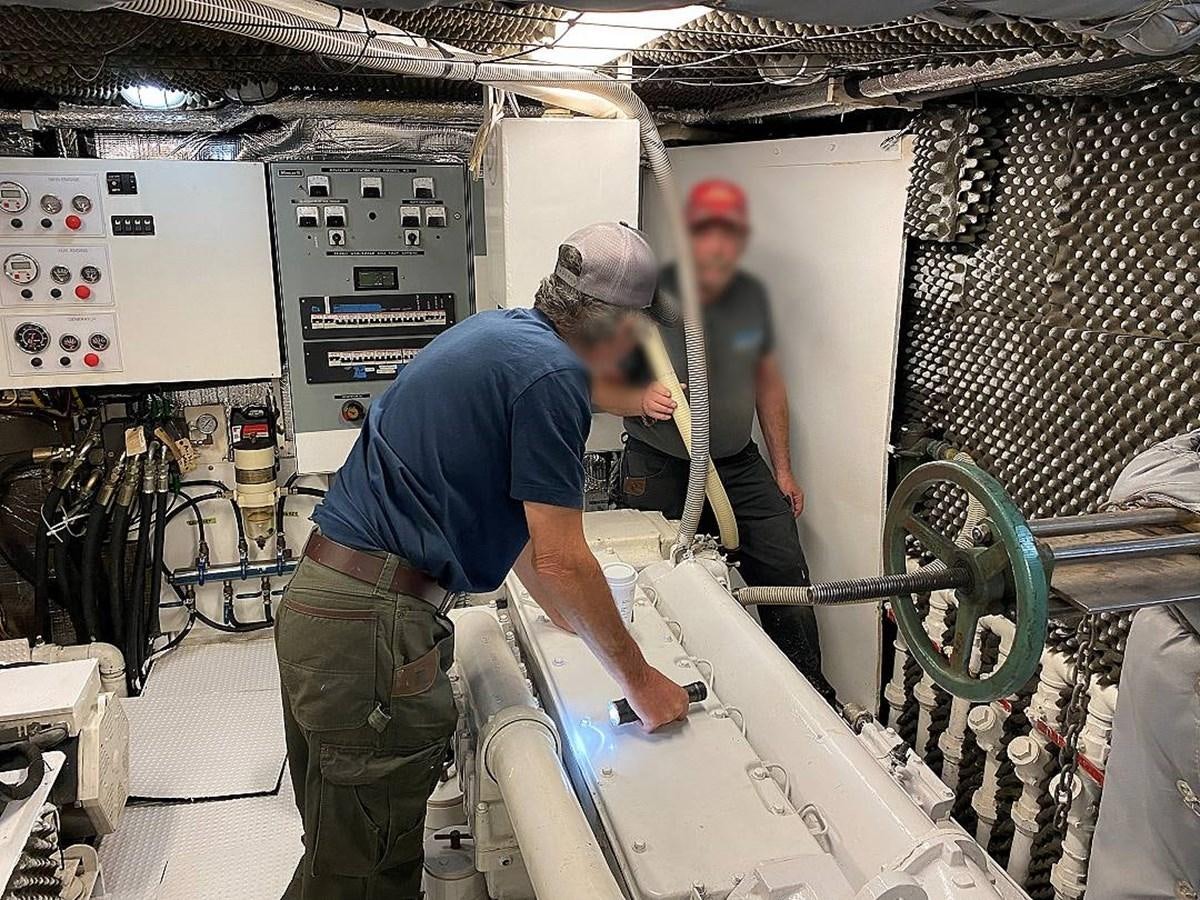 a man working on a machine aboard BEAR PAW Yacht for Sale