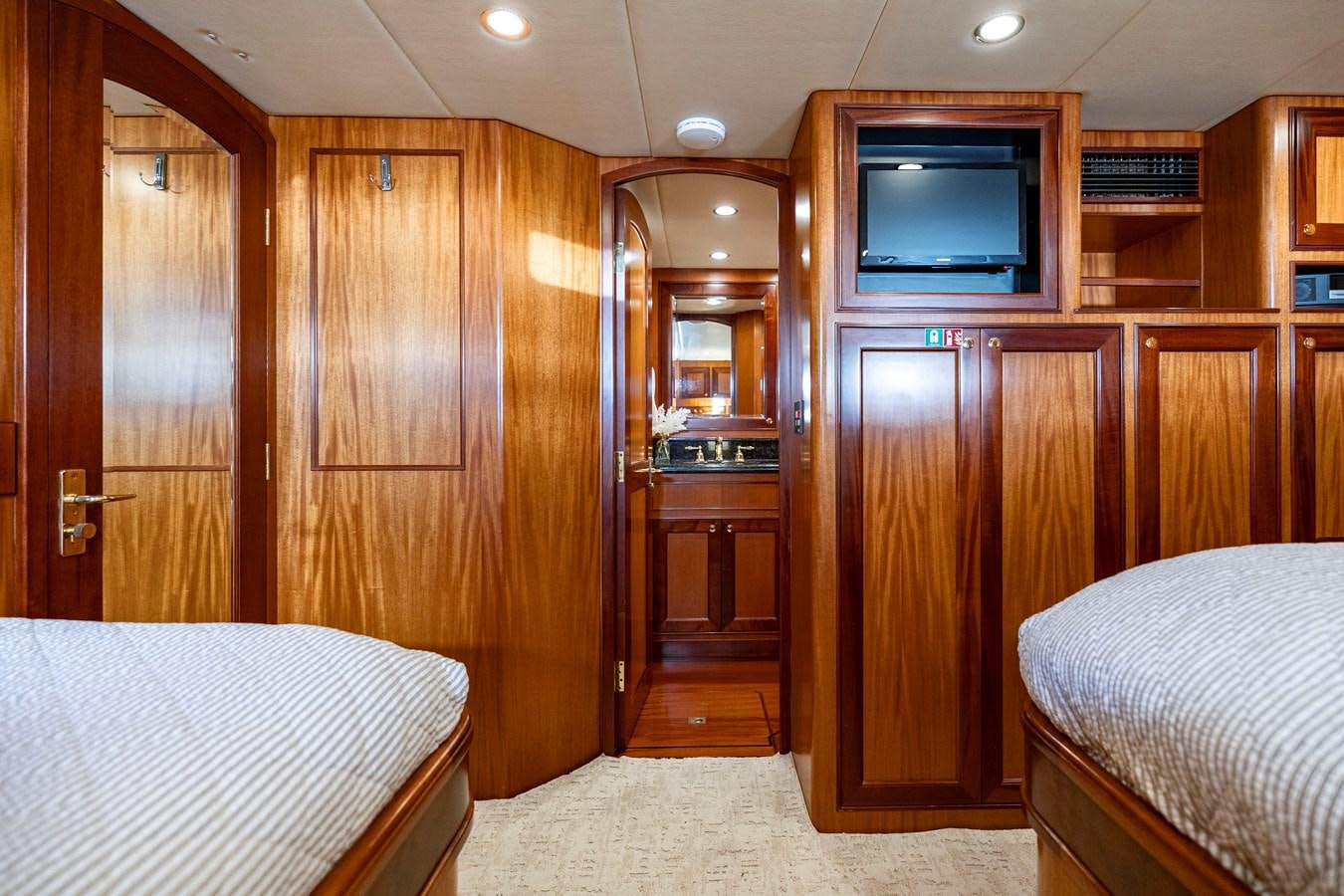 a bedroom with wooden cabinets aboard ANNIE Yacht for Sale