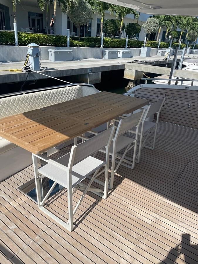 a wooden table on a deck aboard MON TON Yacht for Sale