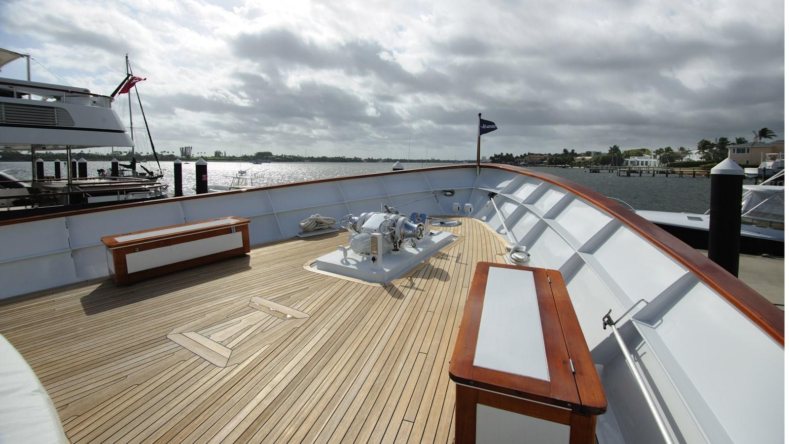 a deck with a boat and a dock with a flag on it aboard AVANTE V Yacht for Sale