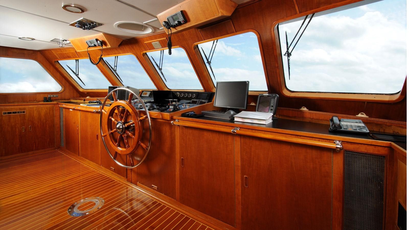 a wooden courtroom with a large round wheel aboard AVANTE V Yacht for Sale