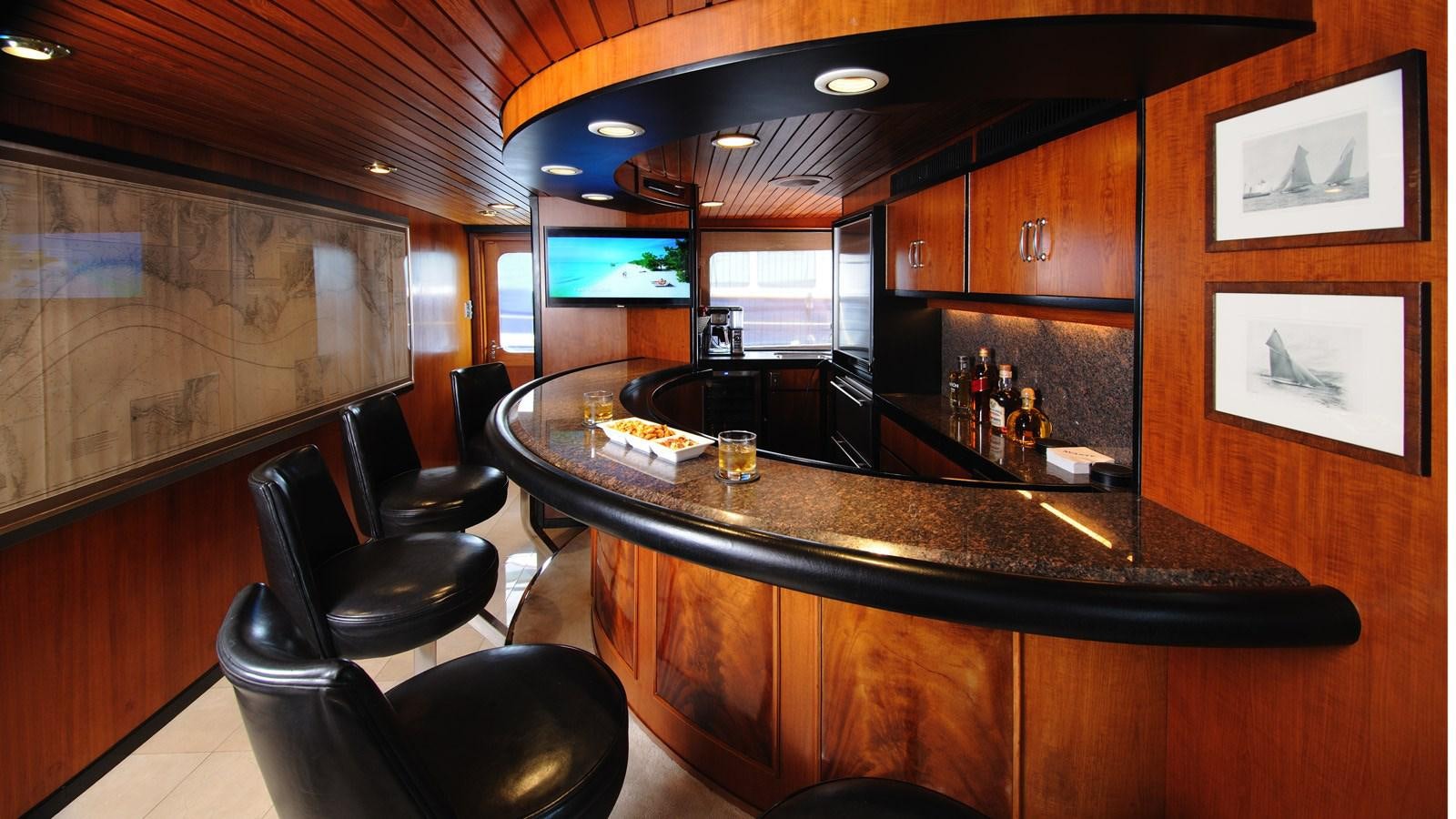 a bar with a bar and chairs aboard AVANTE V Yacht for Sale