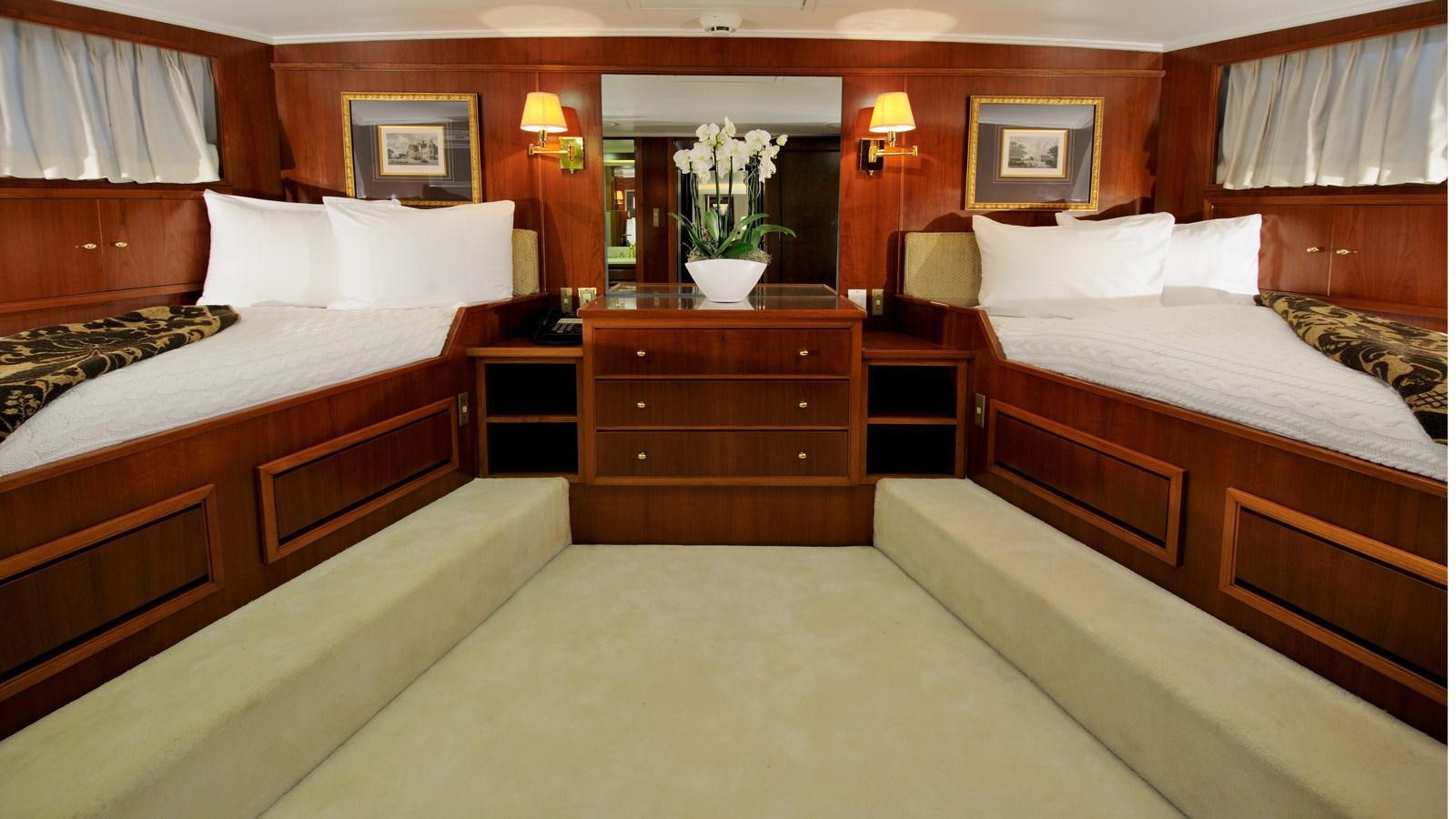 a room with beds and a dresser aboard AVANTE V Yacht for Sale