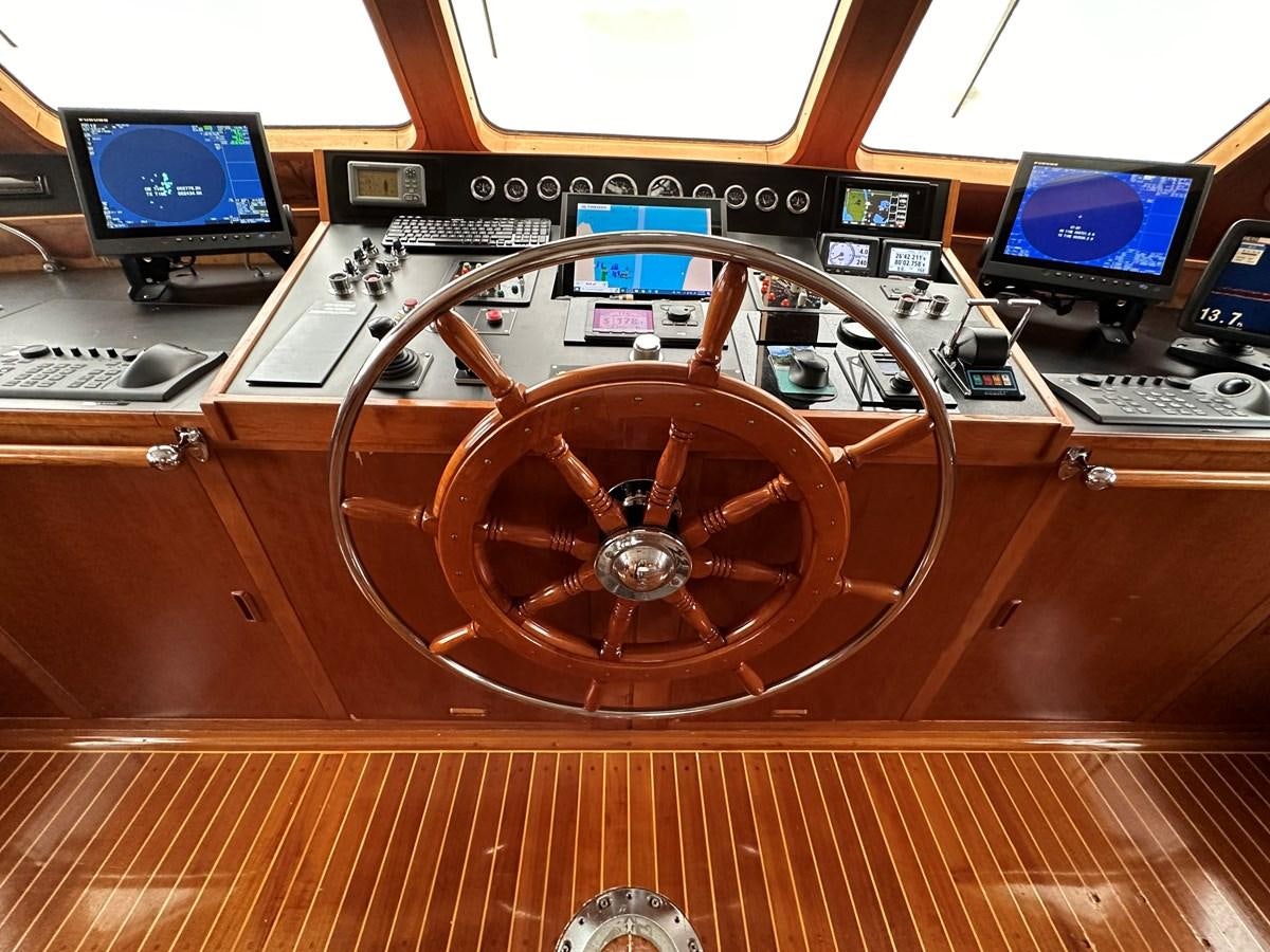 a wooden steering wheel on a wooden table aboard AVANTE V Yacht for Sale