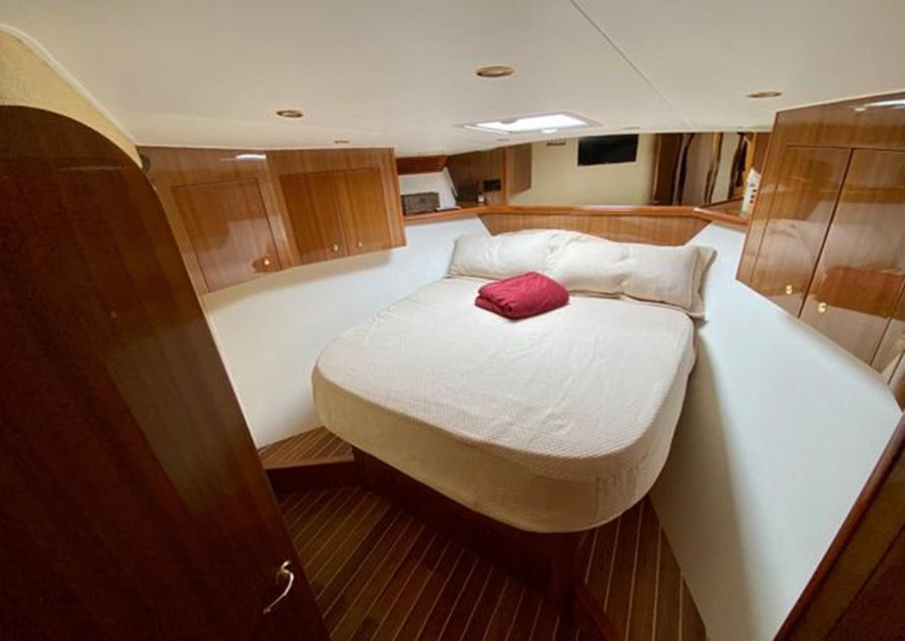 a room with a bed and a television aboard LIKE WHAT U SEA Yacht for Sale