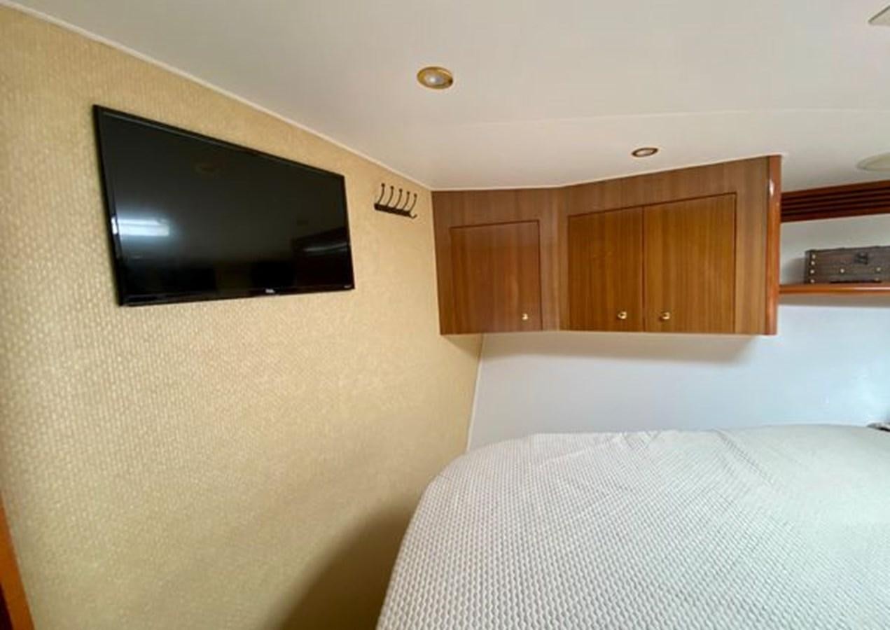 a bedroom with a tv on the wall aboard LIKE WHAT U SEA Yacht for Sale
