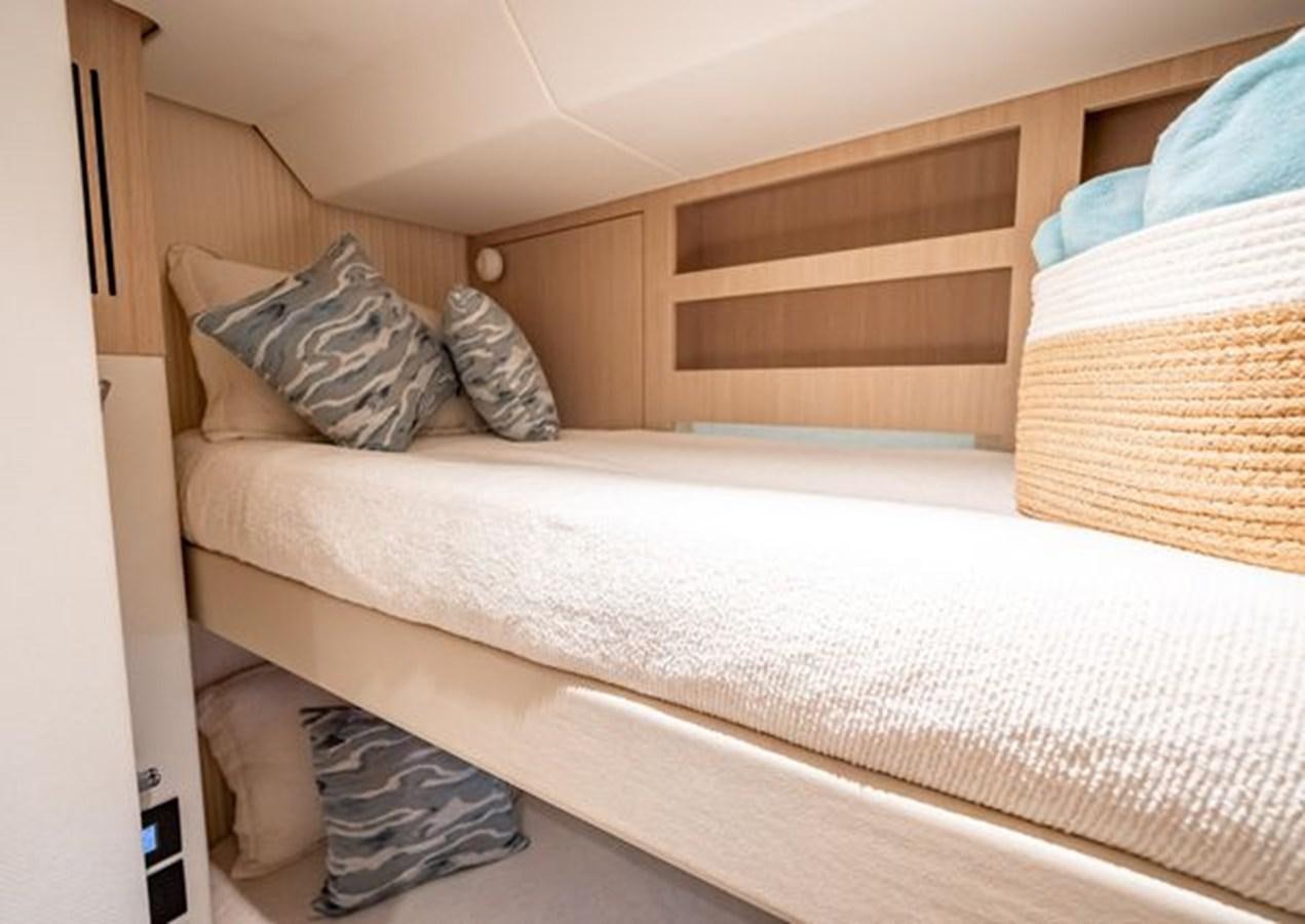 a bed with a white sheet and a wooden headboard aboard AZIMUT MAGELLANO 30/15 Yacht for Sale