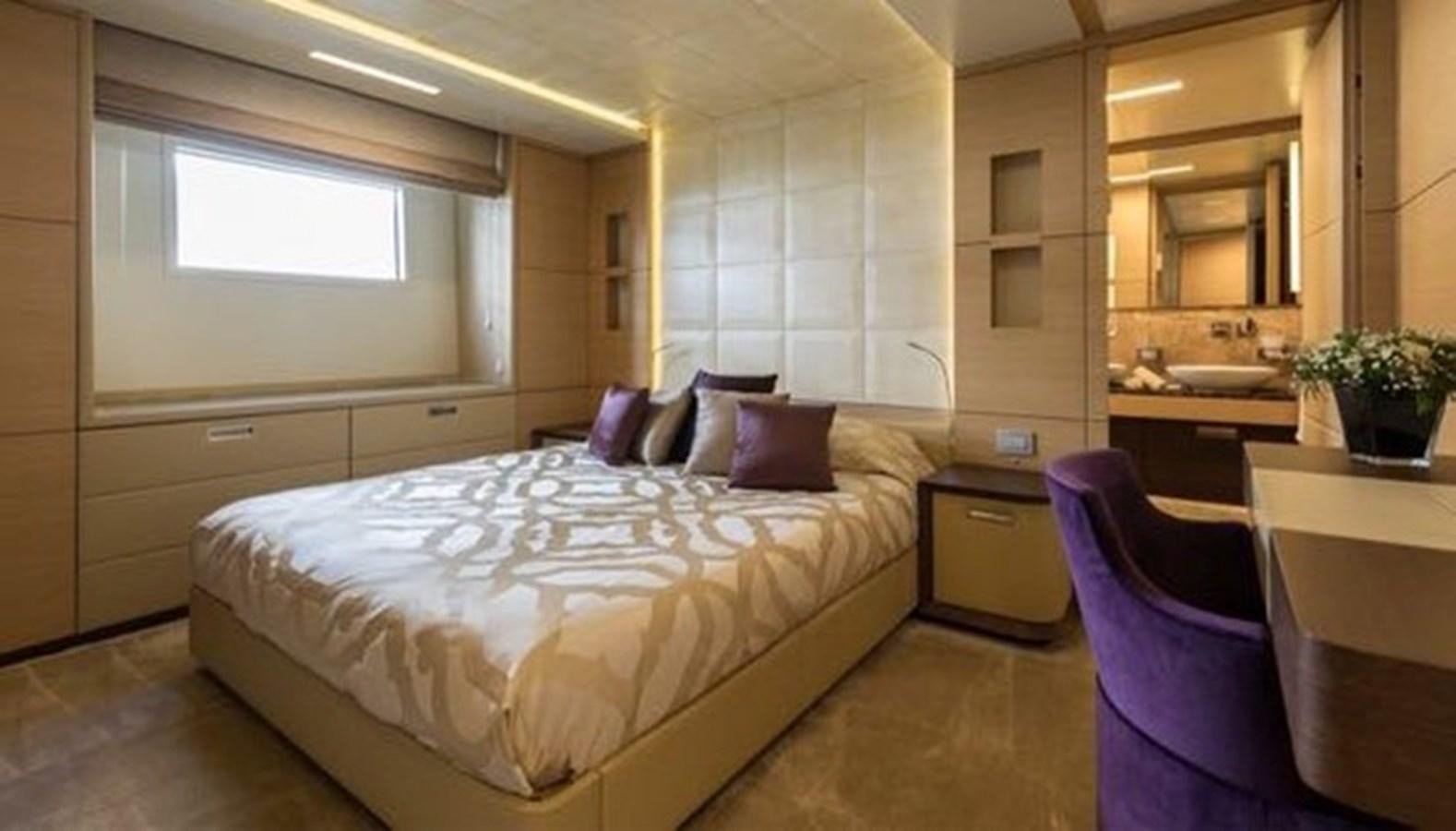 a bedroom with a bed and a chair aboard BENETTI 132 Yacht for Sale