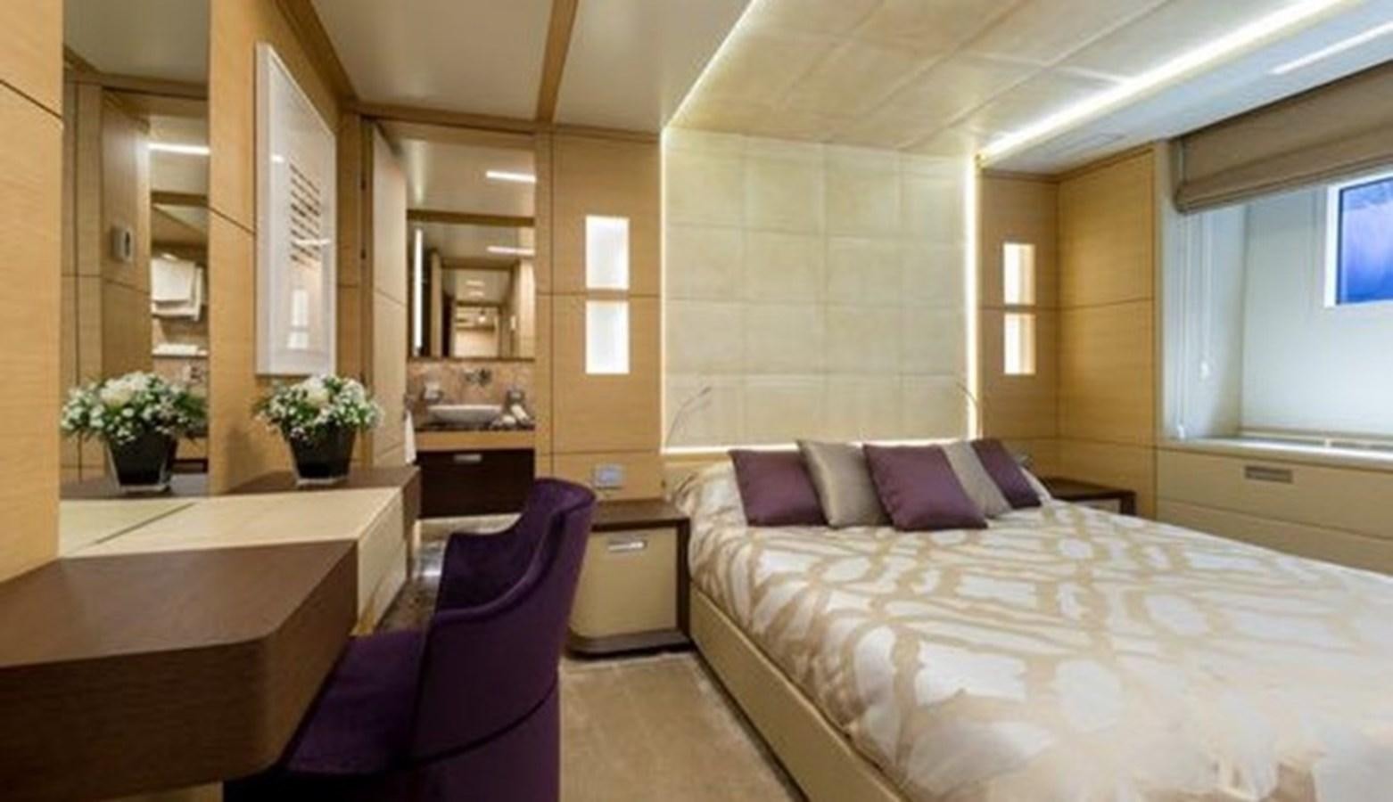 a bedroom with a bed and a chair aboard BENETTI 132 Yacht for Sale
