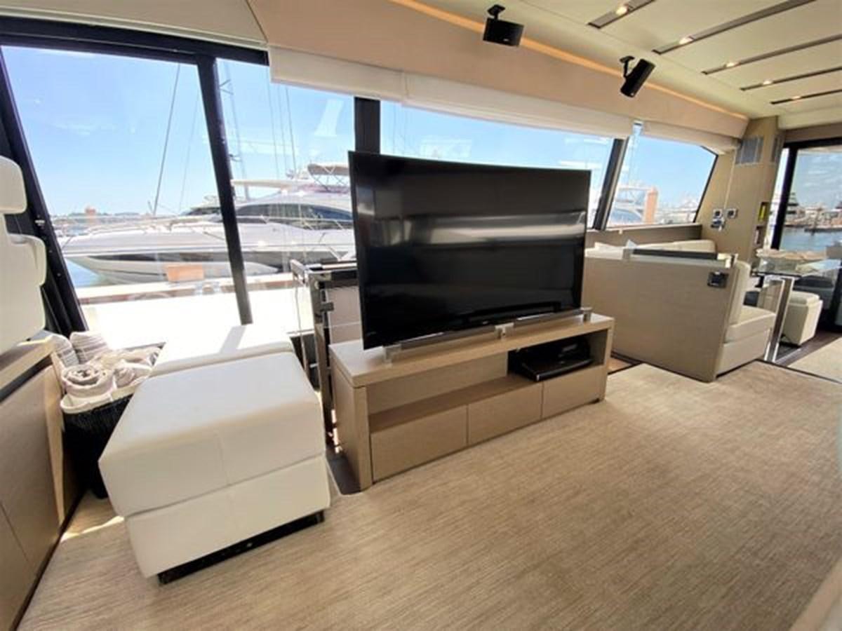 a living room with a large flat screen television and a large window aboard 2016 PRESTIGE 680 FLY Yacht for Sale