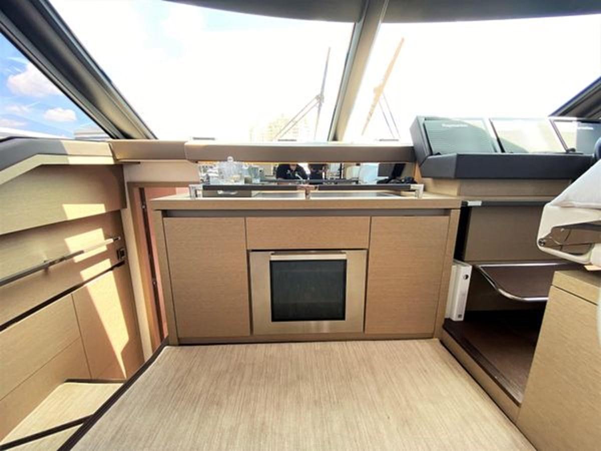 a room with a microwave oven and a wooden floor aboard 2016 PRESTIGE 680 FLY Yacht for Sale