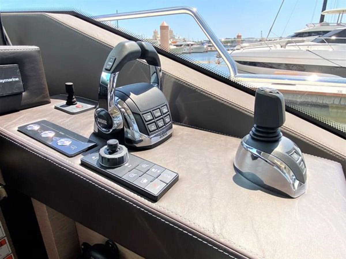 a car dashboard with a phone and a camera on it aboard 2016 PRESTIGE 680 FLY Yacht for Sale