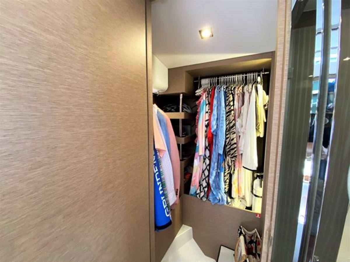 a closet with clothes on the wall aboard 2016 PRESTIGE 680 FLY Yacht for Sale
