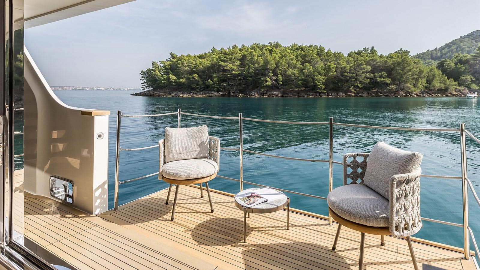a couple chairs on a deck overlooking a body of water aboard ANDIAMO Yacht for Sale