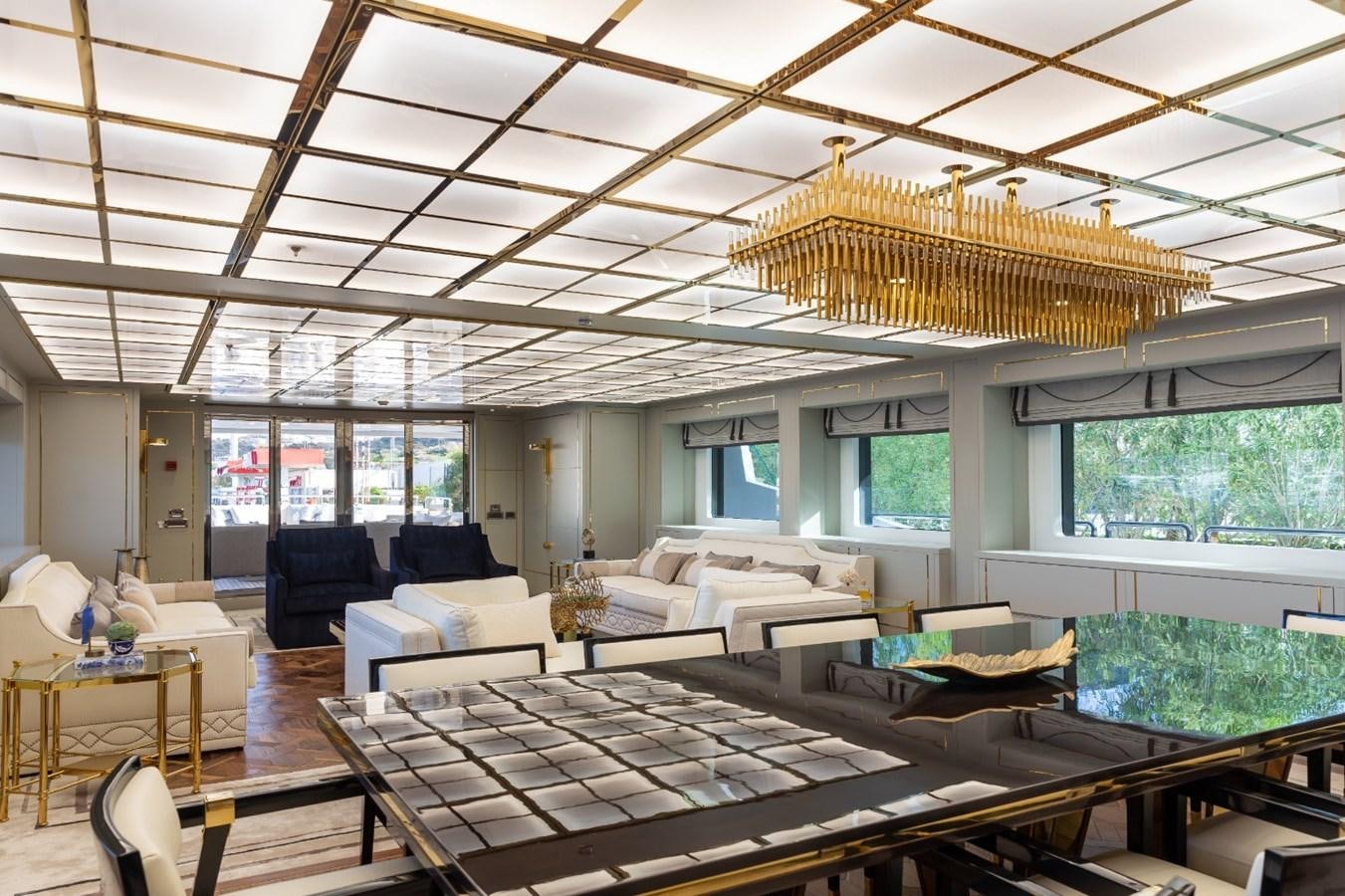 a large living room with a chandelier aboard N.M.N Yacht for Sale