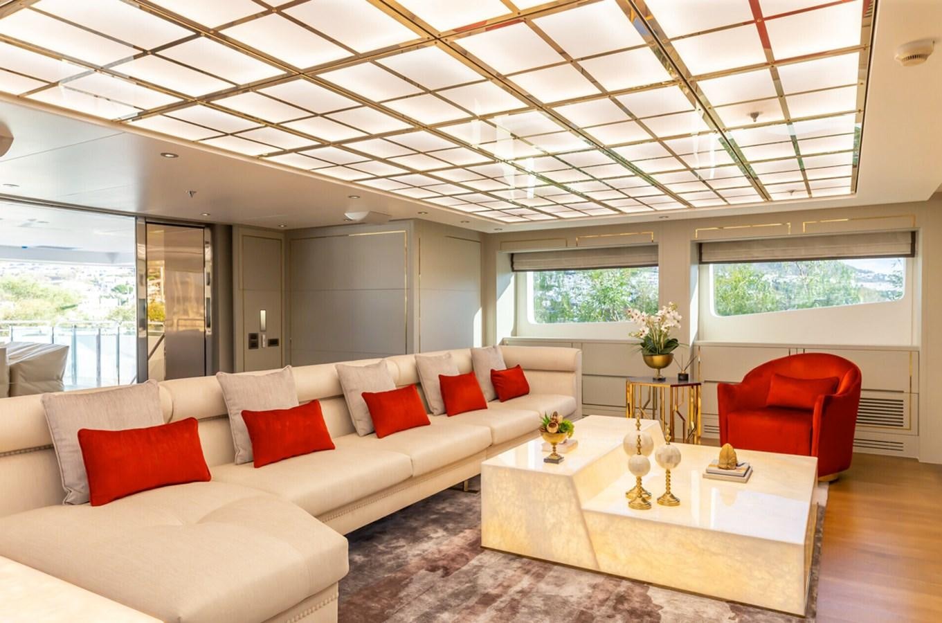 a living room with a white couch and red pillows aboard N.M.N Yacht for Sale