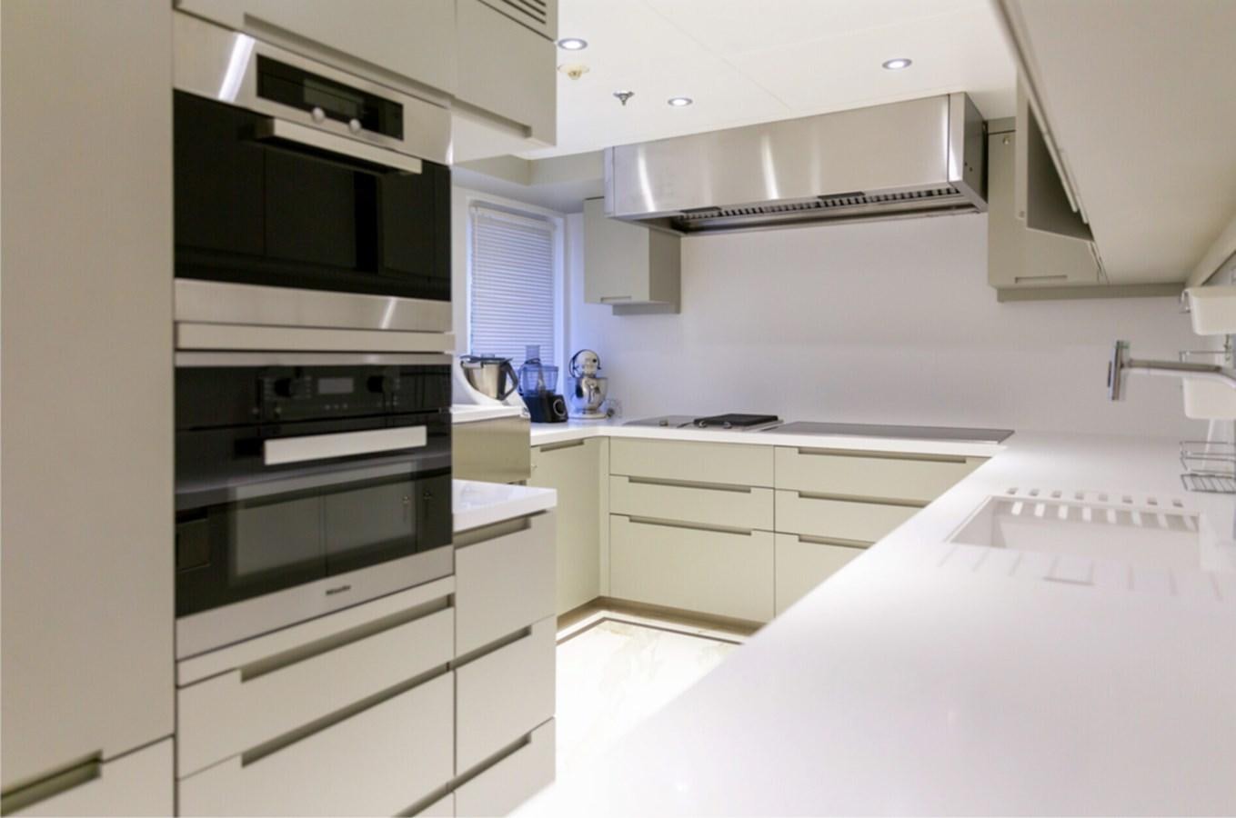 a kitchen with white cabinets aboard N.M.N Yacht for Sale
