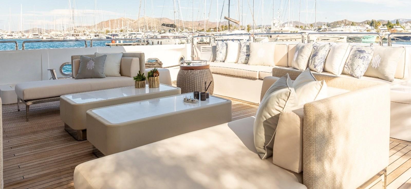 a room with a couch and a table with pillows aboard N.M.N Yacht for Sale