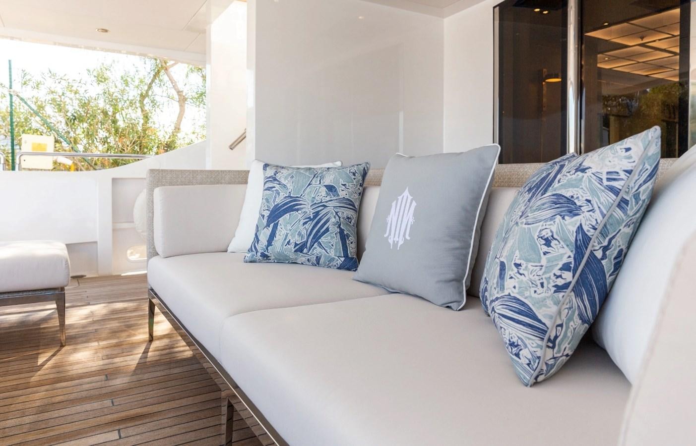 a white couch with blue pillows aboard N.M.N Yacht for Sale