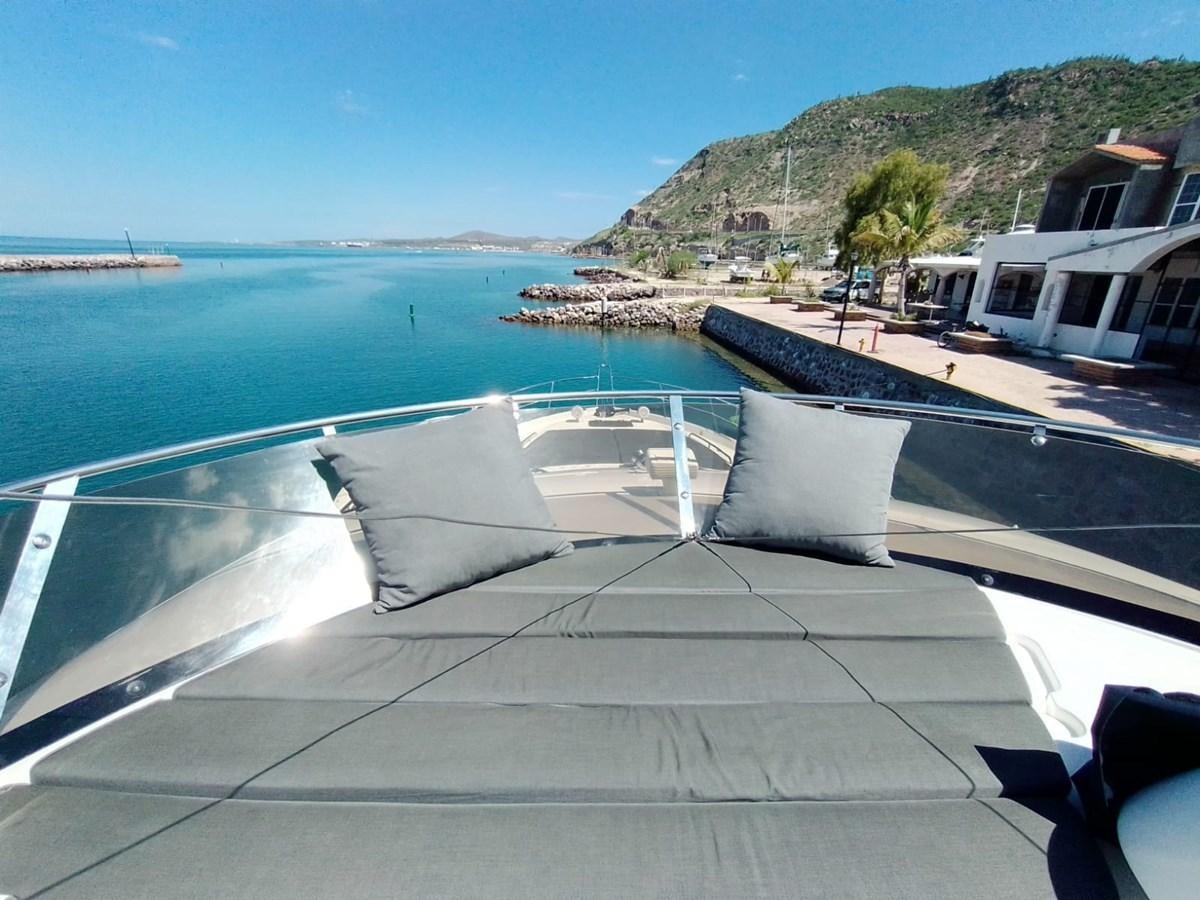 a deck with a pool and a beach and a building in the background aboard CAPRICHO Yacht for Sale
