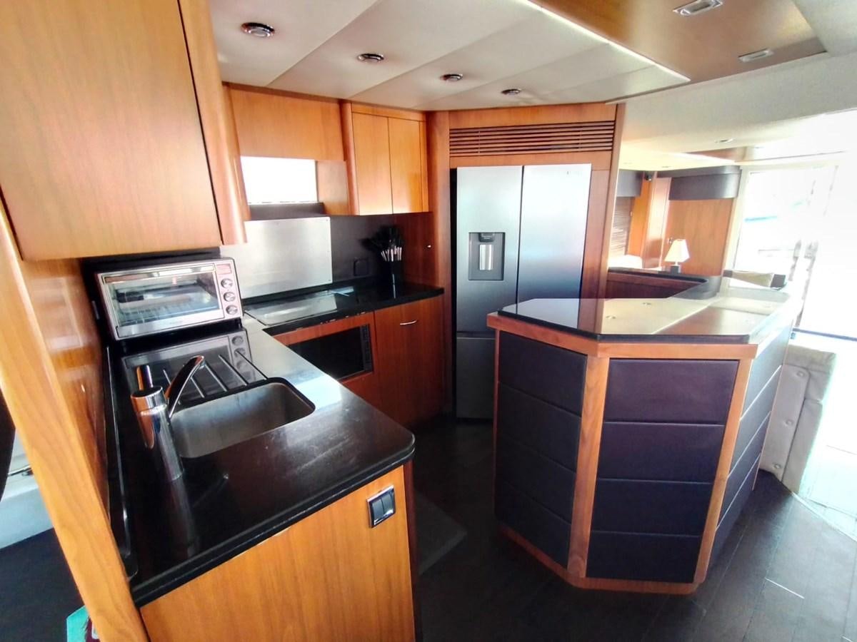 a kitchen with wooden cabinets aboard CAPRICHO Yacht for Sale