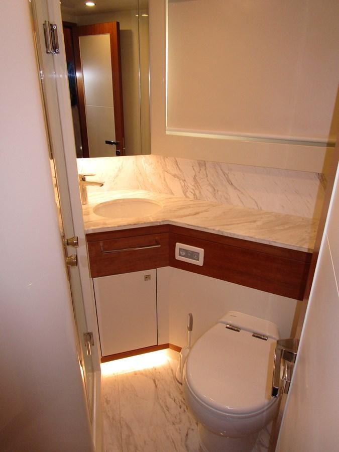 a bathroom with a toilet and sink aboard JOHNSON 83 SKYLOUNGE Yacht for Sale