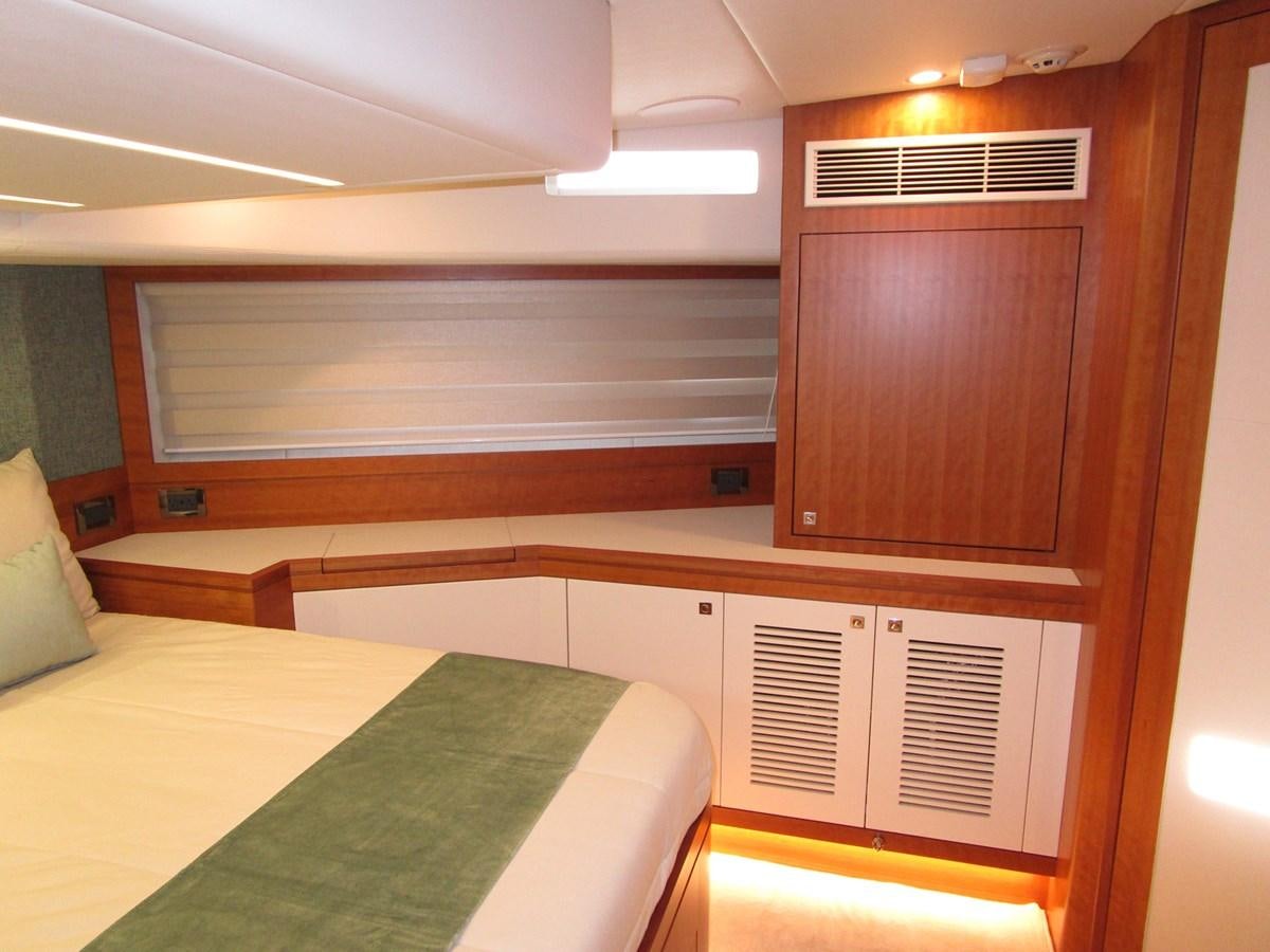 a room with a bed and cabinets aboard JOHNSON 83 SKYLOUNGE Yacht for Sale
