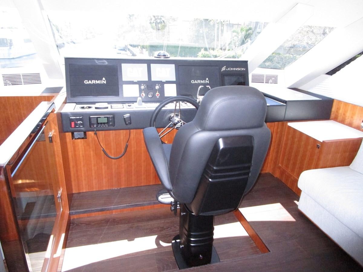 a black office chair in front of a desk with a computer and a window aboard JOHNSON 83 SKYLOUNGE Yacht for Sale