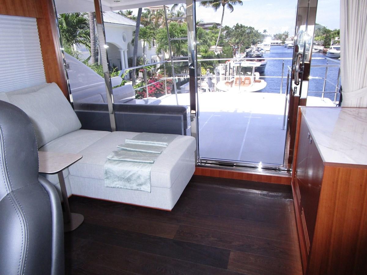 a couch and a table in a room with a window aboard JOHNSON 83 SKYLOUNGE Yacht for Sale