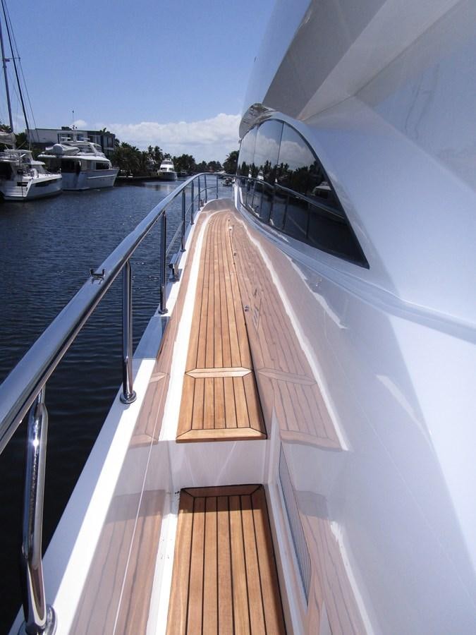a deck with a railing and a boat in the water aboard JOHNSON 83 SKYLOUNGE Yacht for Sale