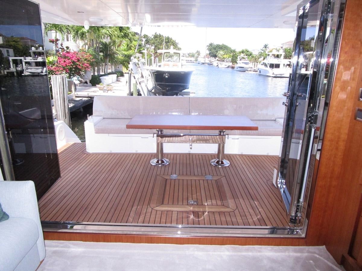 a table and chairs on a deck aboard JOHNSON 83 SKYLOUNGE Yacht for Sale