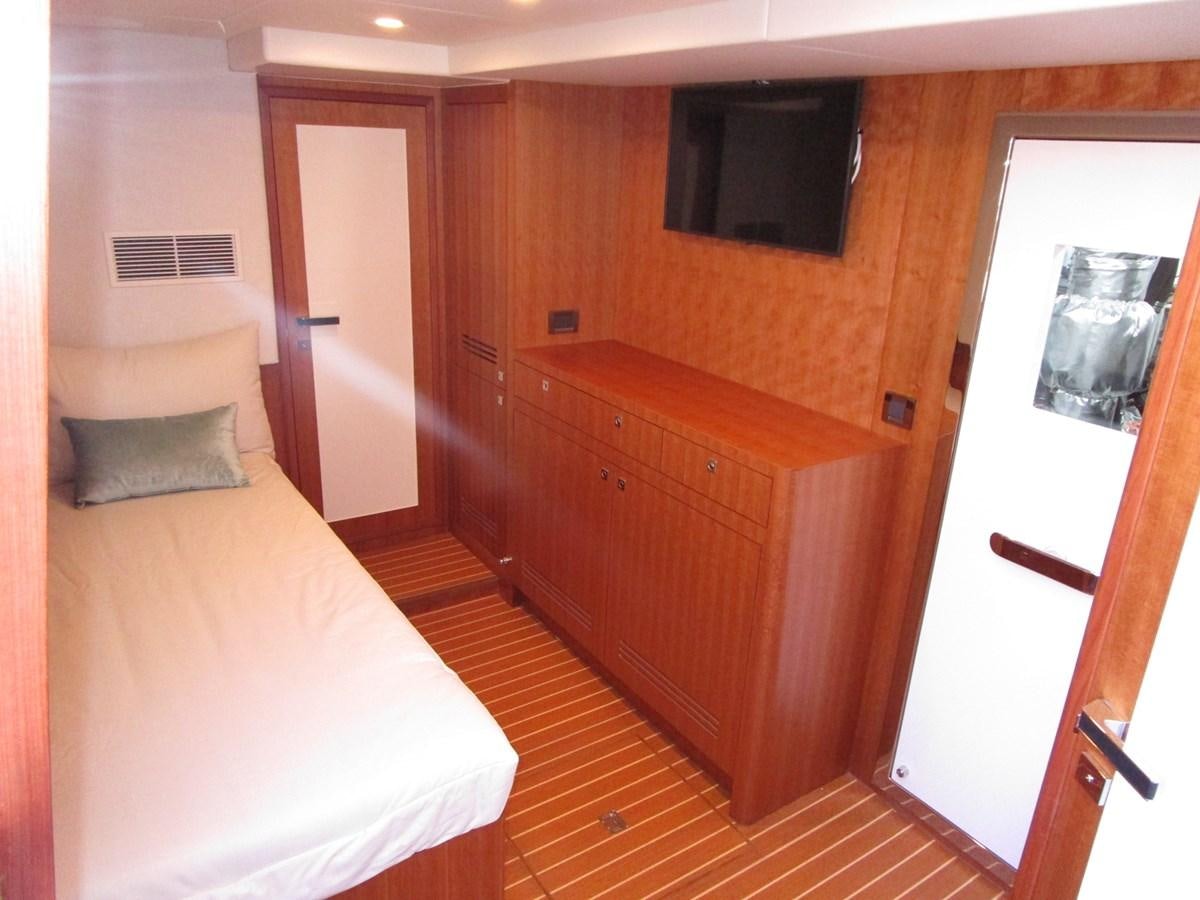 a room with a bed and a television aboard JOHNSON 83 SKYLOUNGE Yacht for Sale