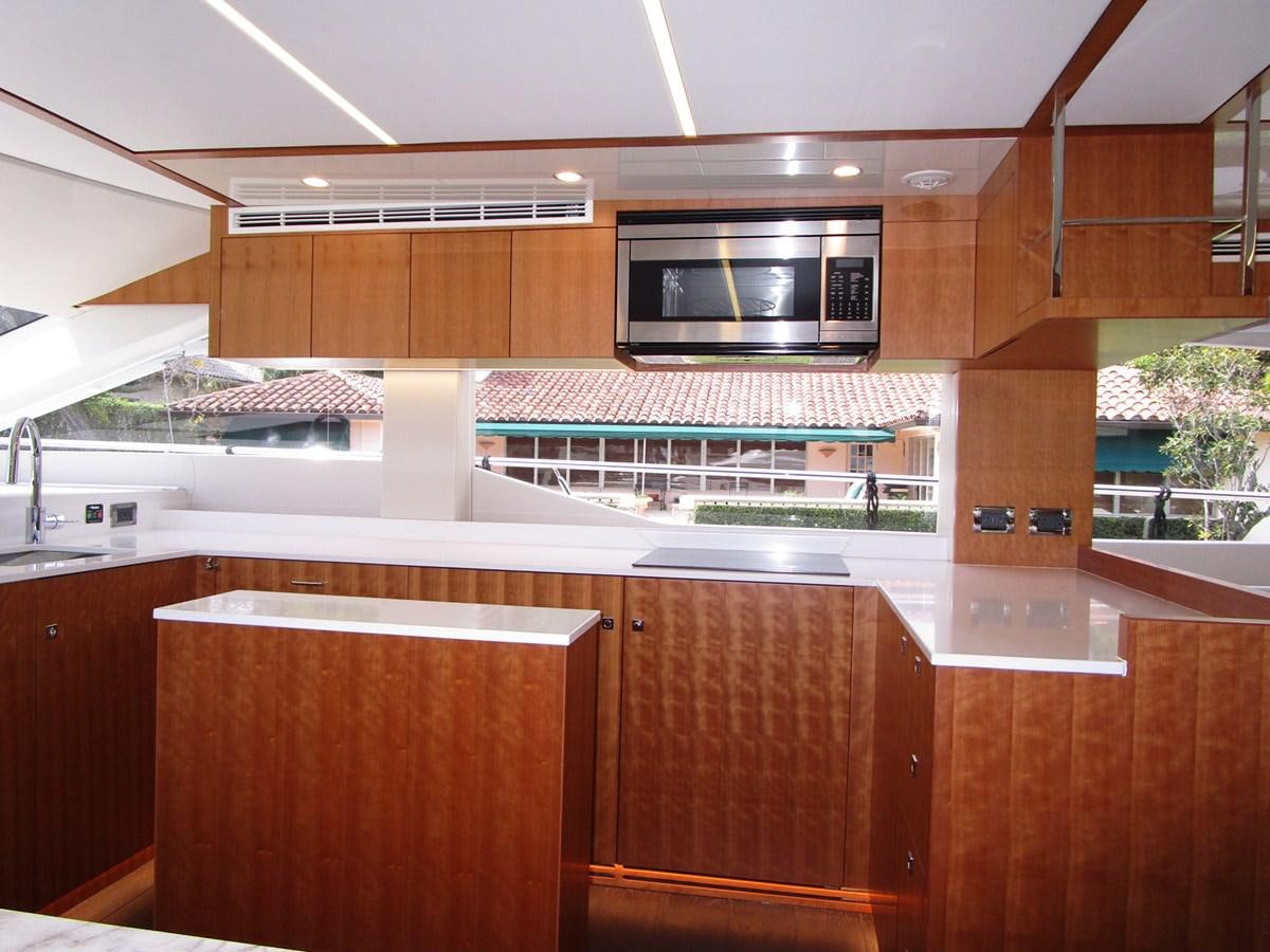 a kitchen with wooden cabinets aboard JOHNSON 83 SKYLOUNGE Yacht for Sale