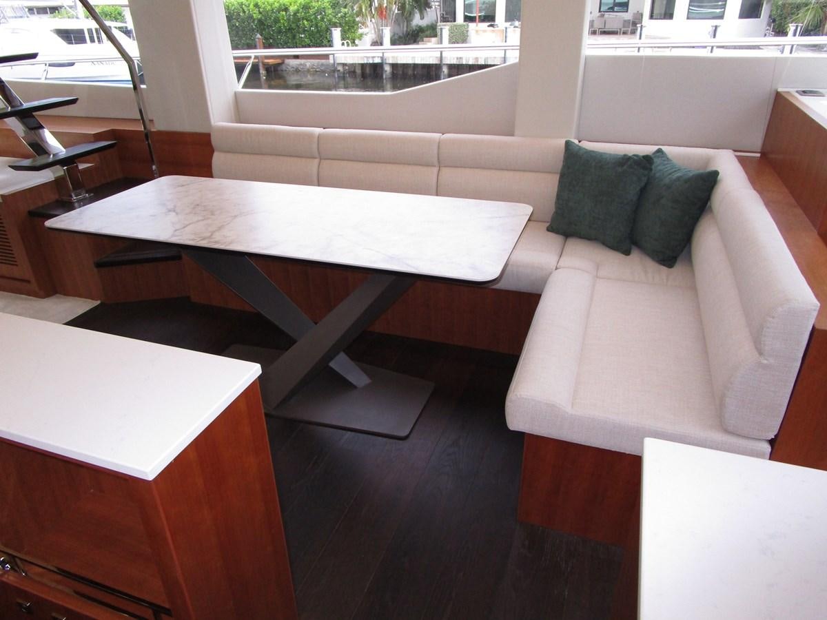 a couch with a table and chairs aboard JOHNSON 83 SKYLOUNGE Yacht for Sale