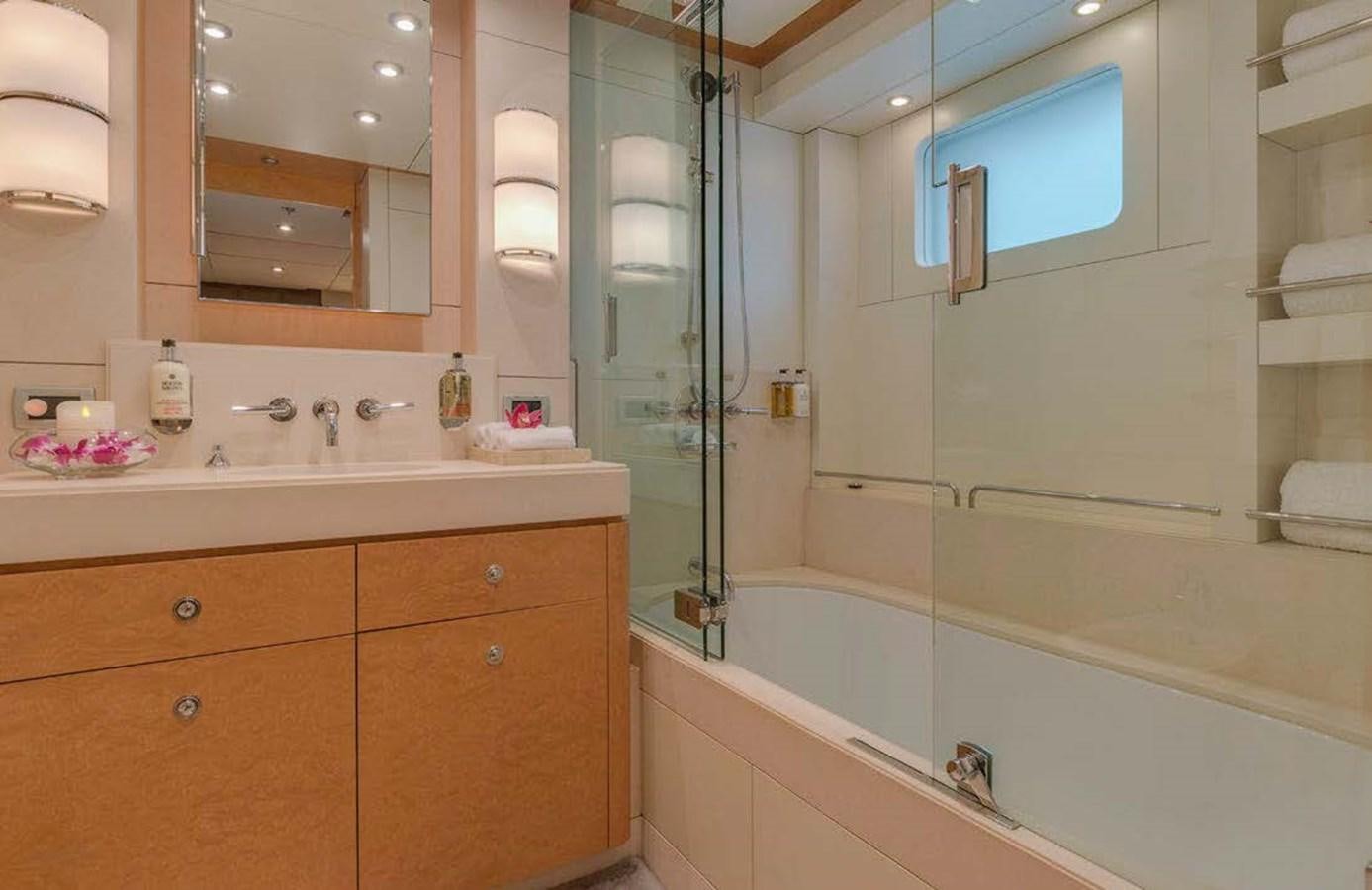 a bathroom with a tub sink and cabinets aboard MIZU Yacht for Sale