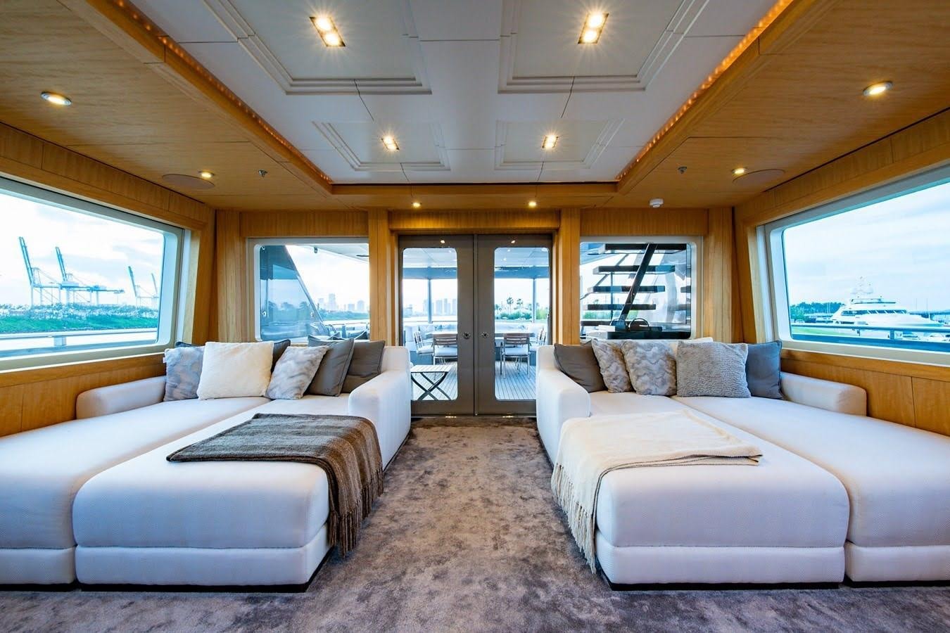 a living room with a couch and a large window aboard MIZU Yacht for Sale