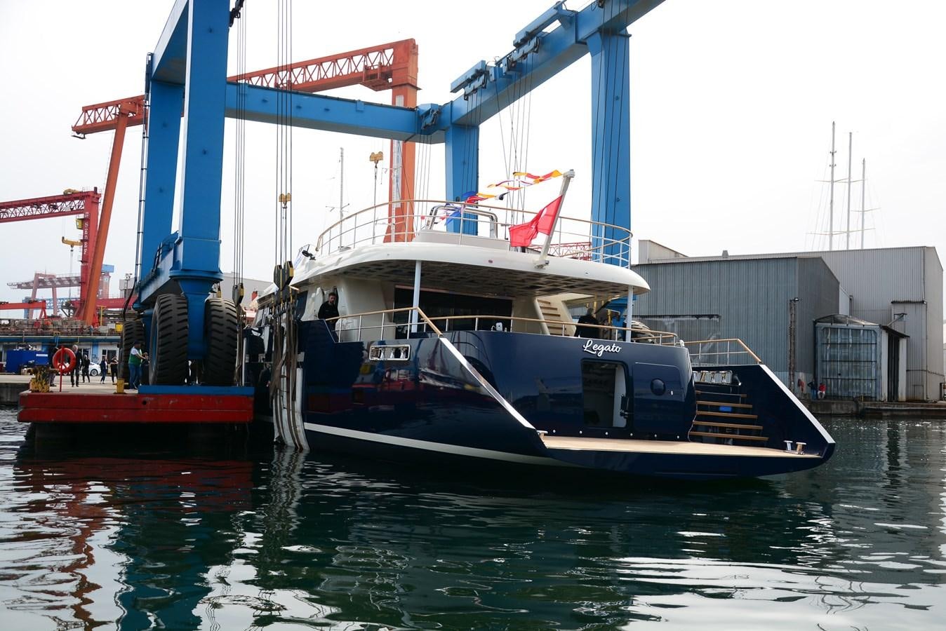 a large boat docked at a port aboard LEGATO Yacht for Sale