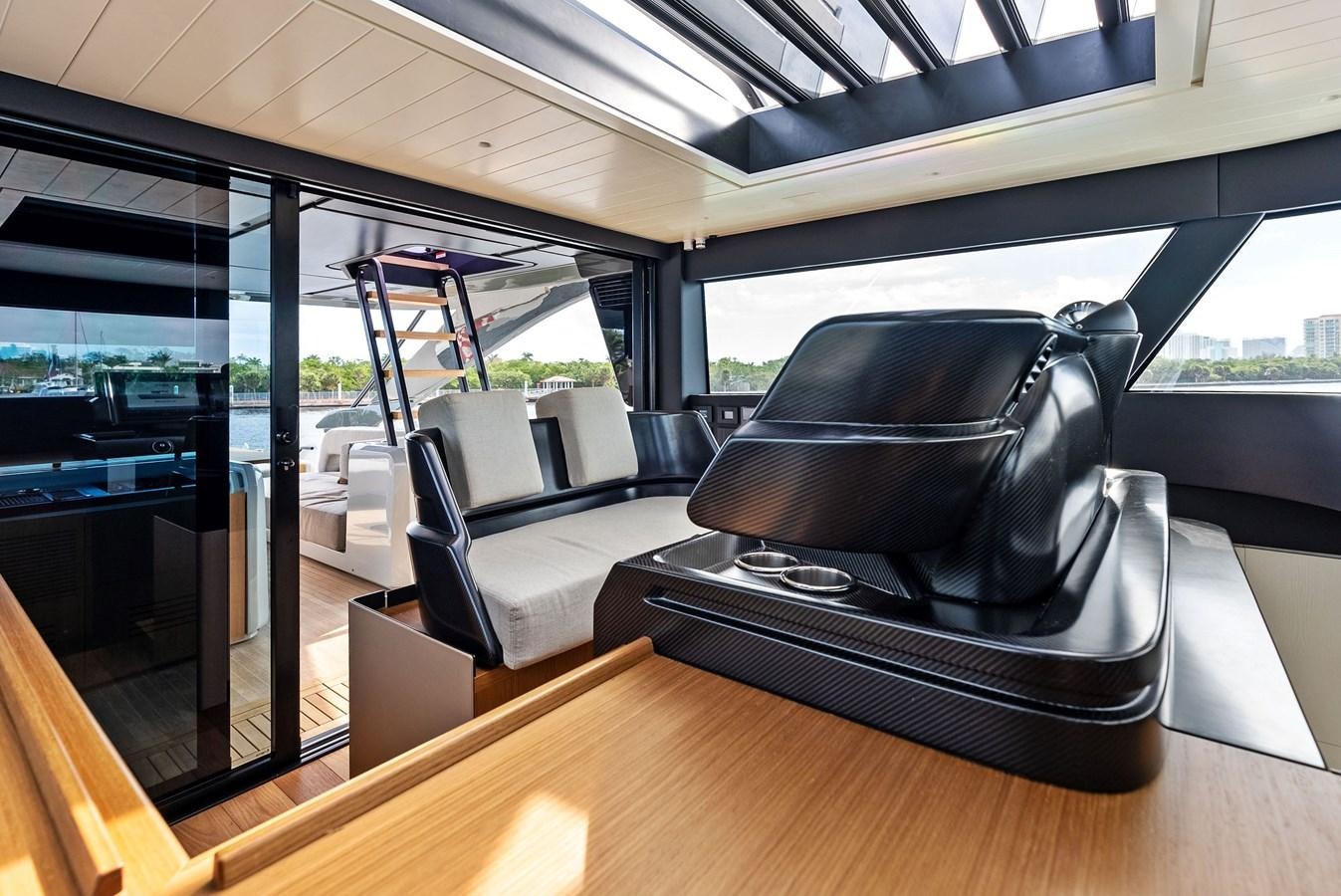 a black leather chair on a wooden deck aboard SNACK MONEY Yacht for Sale