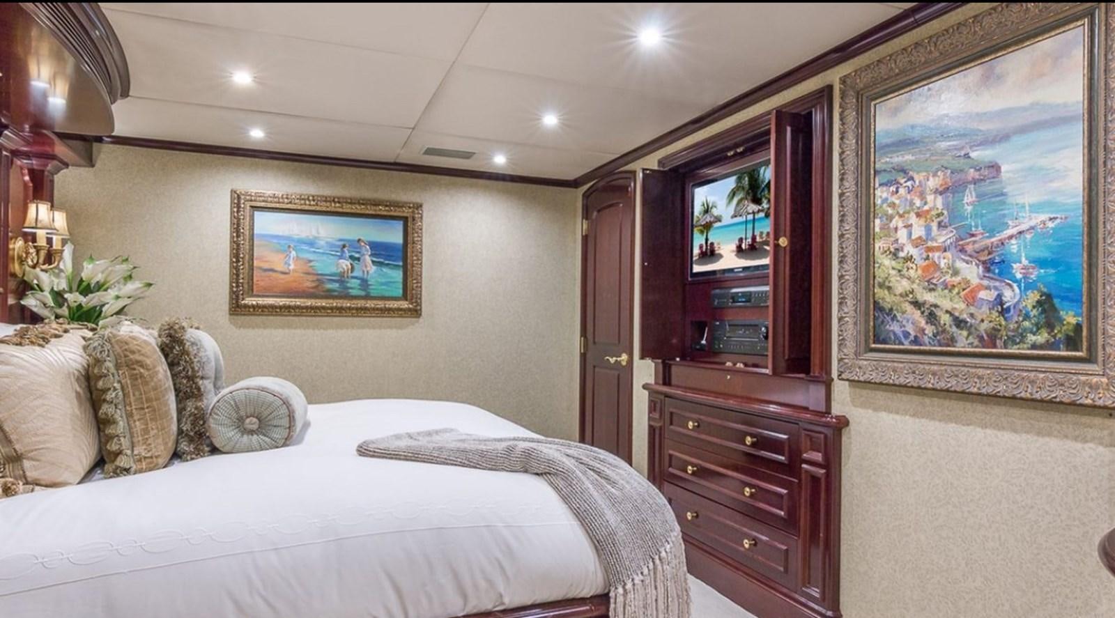 a bedroom with a large bed and a tv on the wall aboard TRUE LOVE Yacht for Sale